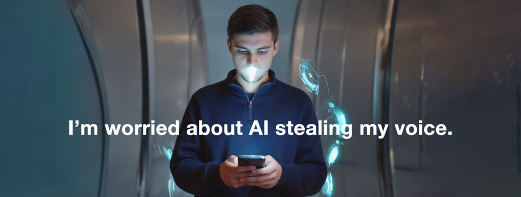 a young man in a futuristic setting, looking intently at his smartphone. A bright, blue light emanates from his mouth, visually representing his voice being captured or digitized by the phone. Holographic, high-tech graphics float in the air around him. Superimposed over the scene is white text that reads: "I'm worried about AI stealing my voice."